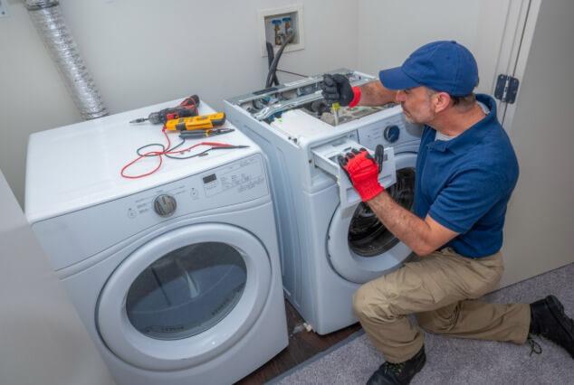 busy repairman fixing broken refrigerator in Congers